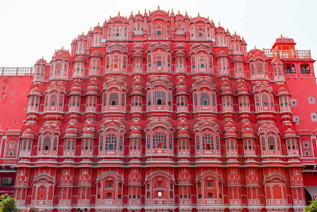 Facade of Hawa Mahal in Jaipur with intricate pink sandstone windows and balconies.
