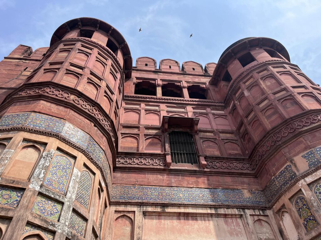 Red sandstone entrance of Bharatpur Fort with intricate carvings and towers